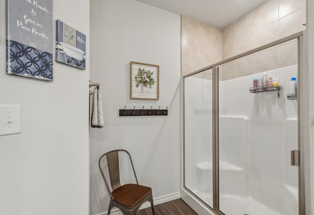 bathroom with a shower with shower door and hardwood / wood-style flooring