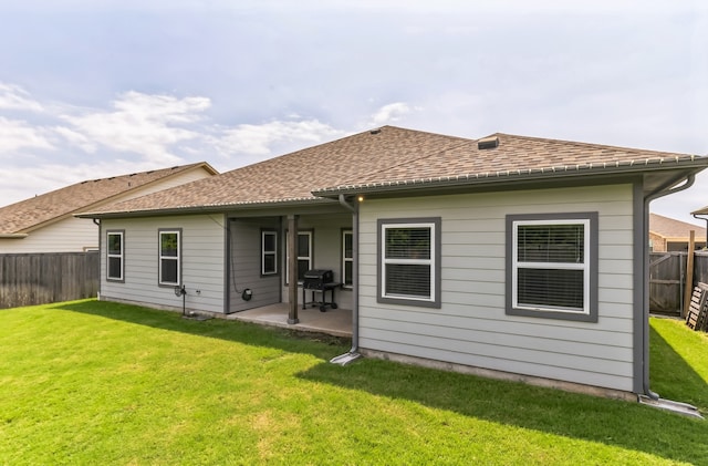 rear view of house with a lawn and a patio area