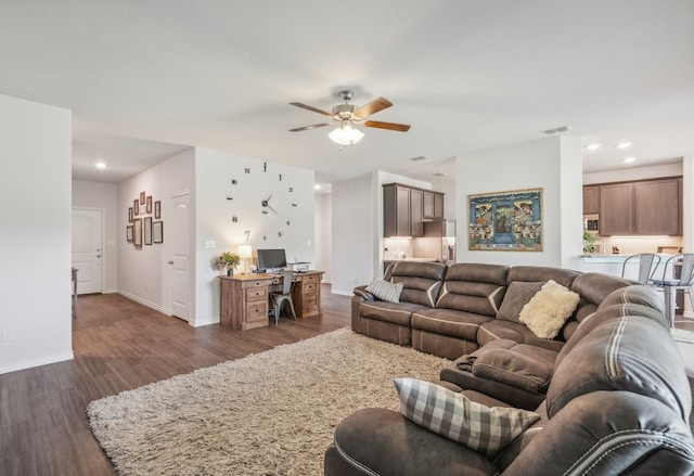 living room featuring ceiling fan and dark hardwood / wood-style flooring