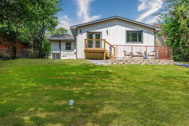 back of house with a lawn, central air condition unit, and a deck