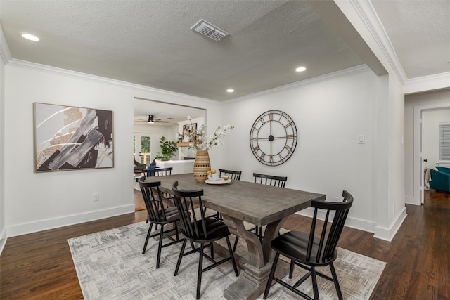 dining space featuring ceiling fan, dark wood-type flooring, ornamental molding, and a textured ceiling