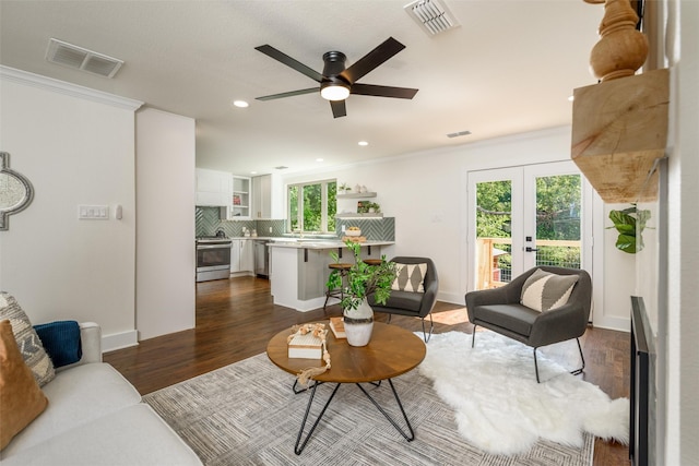 living room featuring dark wood-type flooring, ceiling fan, crown molding, and french doors