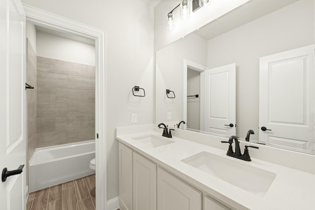 full bathroom with tiled shower / bath combo, vanity, and toilet