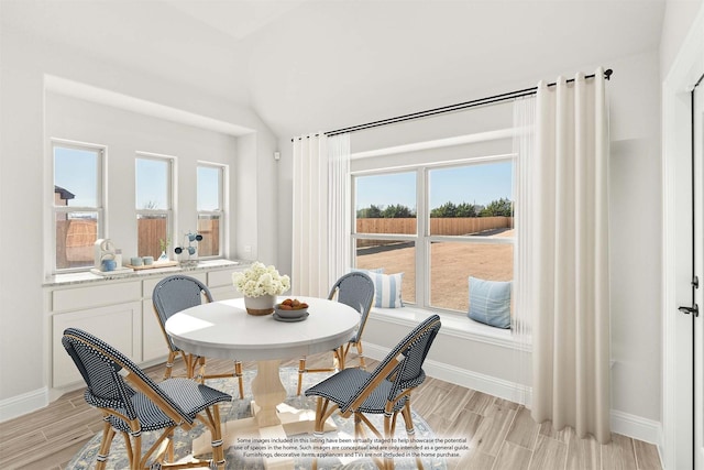 dining area featuring lofted ceiling and a wealth of natural light