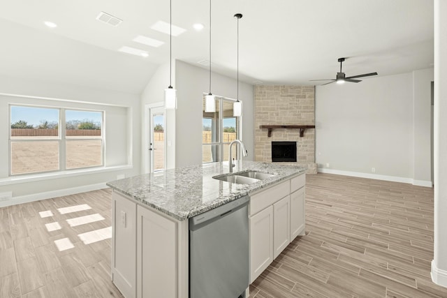 kitchen featuring sink, white cabinetry, a center island with sink, stainless steel dishwasher, and pendant lighting