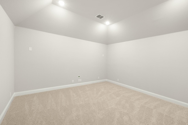 carpeted empty room featuring lofted ceiling