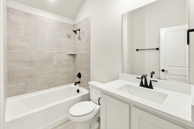 full bathroom featuring vanity, vaulted ceiling, toilet, and tiled shower / bath