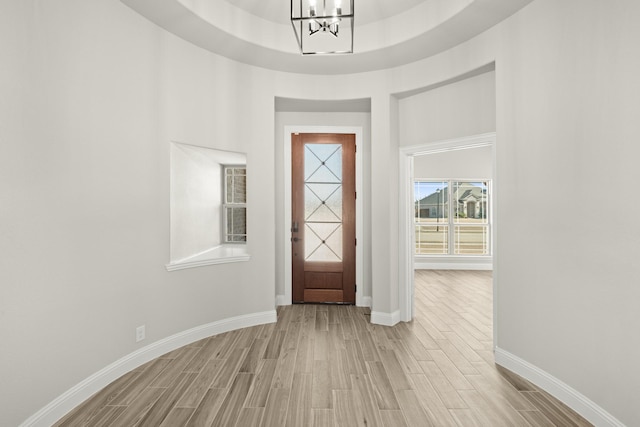 foyer featuring a raised ceiling and a chandelier