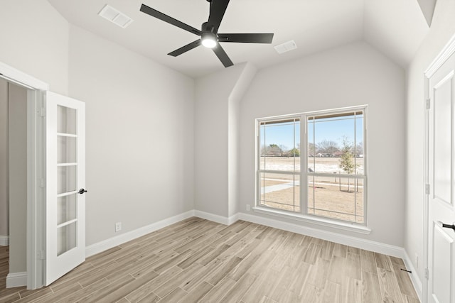 empty room with ceiling fan, vaulted ceiling, and light wood-type flooring