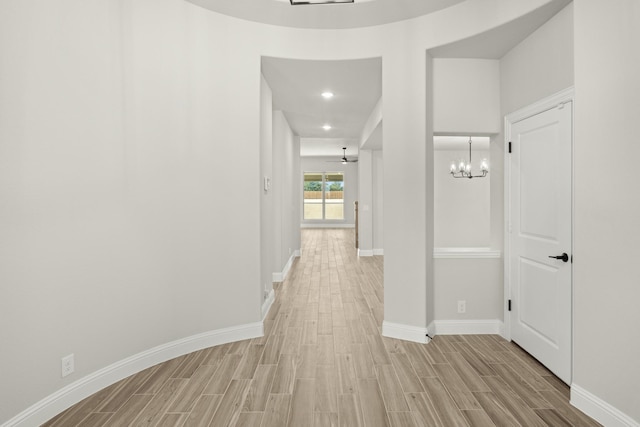 corridor featuring a chandelier and light hardwood / wood-style flooring