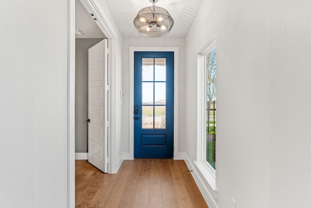 doorway to outside featuring light hardwood / wood-style flooring and a chandelier