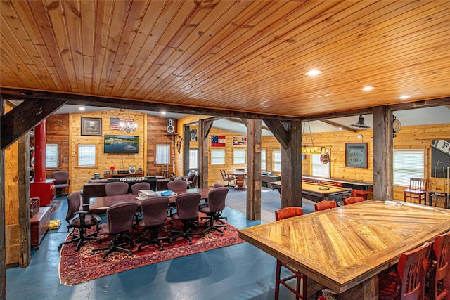 dining room with concrete floors, wood ceiling, and wooden walls