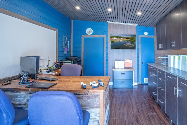 home office with dark wood-type flooring and wood walls