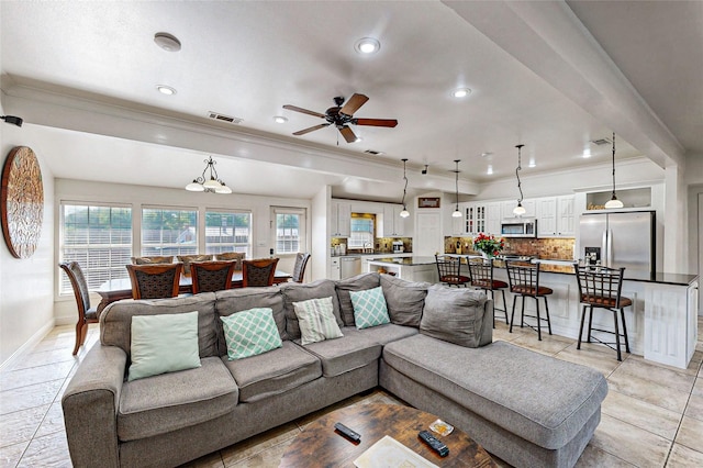 tiled living room with ceiling fan and ornamental molding