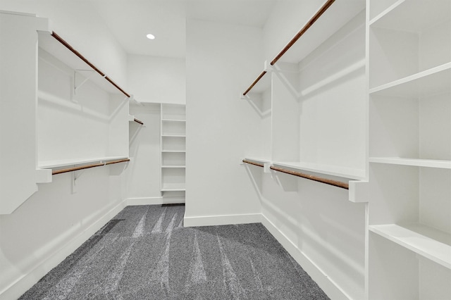 walk in closet featuring dark carpet