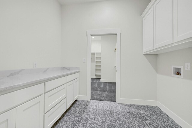 laundry room with washer hookup, cabinets, and light tile patterned flooring