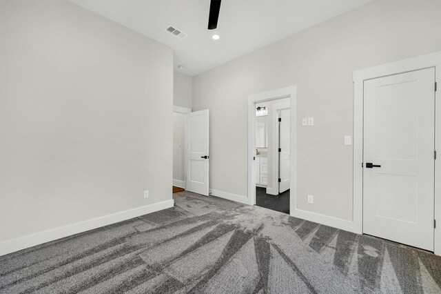 unfurnished bedroom featuring ceiling fan and dark colored carpet