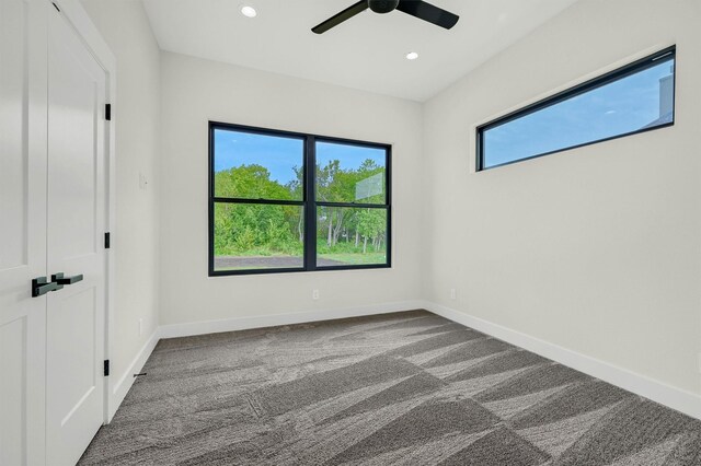 carpeted spare room featuring ceiling fan