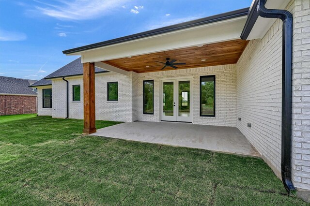 back of property featuring a patio area, a lawn, and ceiling fan