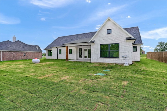 rear view of house featuring a yard and a patio area