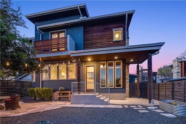 back house at dusk with a patio area