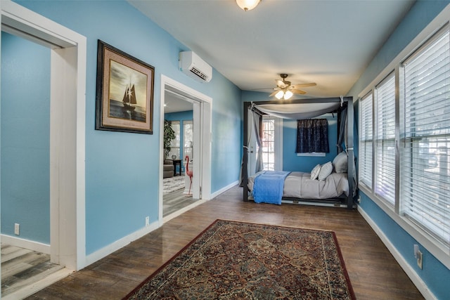 bedroom with an AC wall unit, multiple windows, and dark wood-type flooring