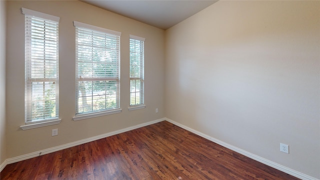 unfurnished room with dark hardwood / wood-style flooring and a healthy amount of sunlight