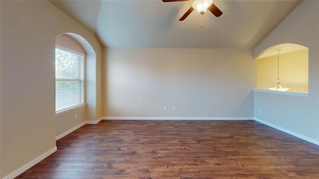 empty room featuring ceiling fan, dark wood-type flooring, and vaulted ceiling