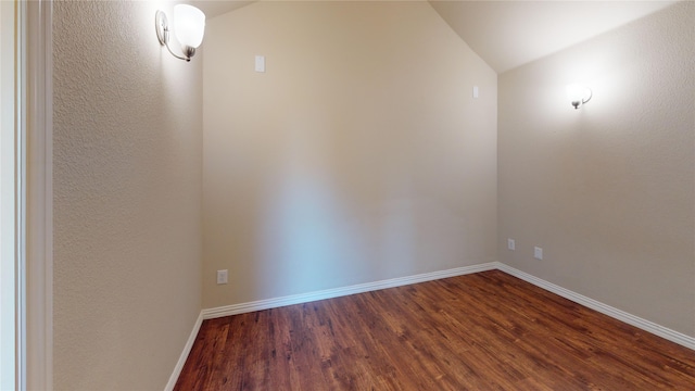 empty room featuring lofted ceiling and dark hardwood / wood-style floors