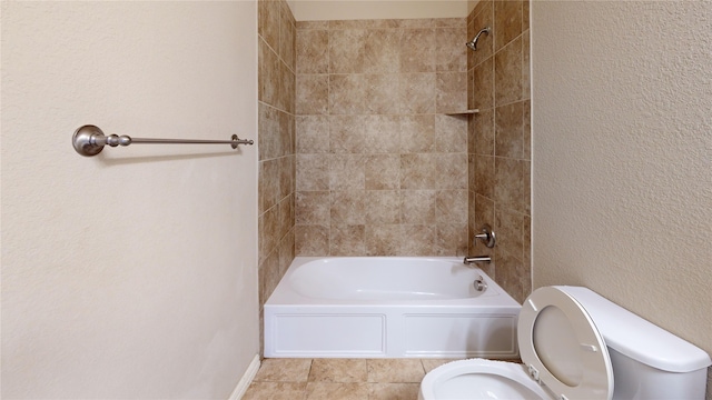 bathroom featuring toilet and tiled shower / bath