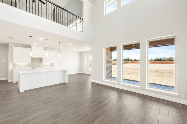 kitchen with a center island with sink, appliances with stainless steel finishes, sink, and light brown cabinetry