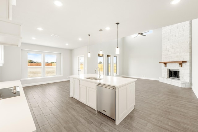 kitchen featuring white cabinets, open floor plan, dishwasher, and light countertops