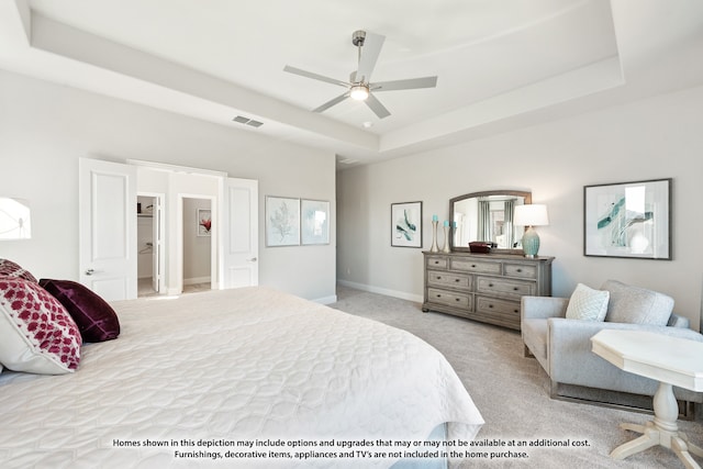 bedroom with ceiling fan, a tray ceiling, and carpet