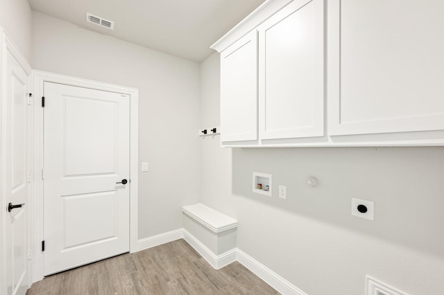 clothes washing area with washer hookup, visible vents, cabinet space, light wood finished floors, and electric dryer hookup