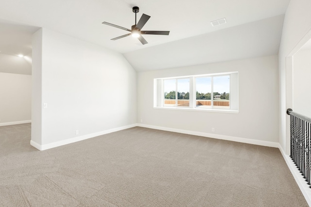 interior space with ceiling fan, vaulted ceiling, and light colored carpet