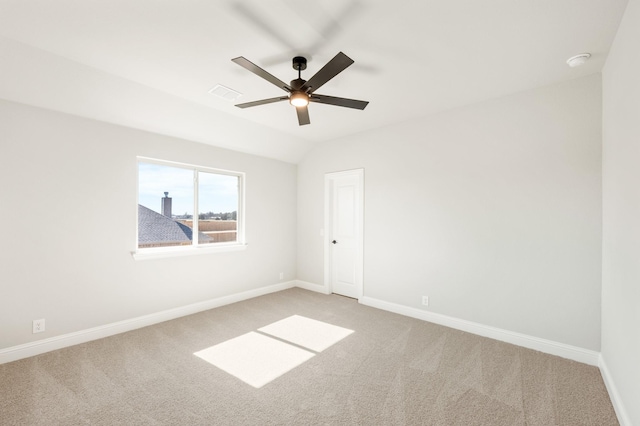 empty room with visible vents, light carpet, vaulted ceiling, ceiling fan, and baseboards