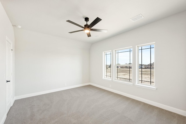 carpeted empty room featuring ceiling fan, visible vents, and baseboards