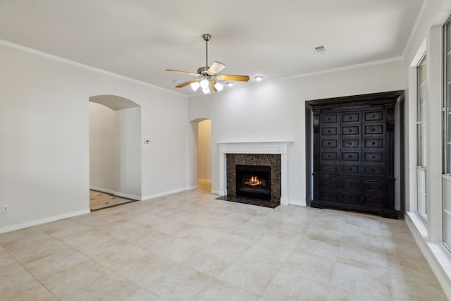 unfurnished living room featuring a high end fireplace, light tile patterned floors, ceiling fan, and crown molding