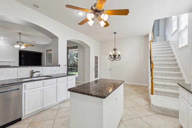 kitchen with light tile patterned floors, white cabinets, sink, tasteful backsplash, and stainless steel dishwasher