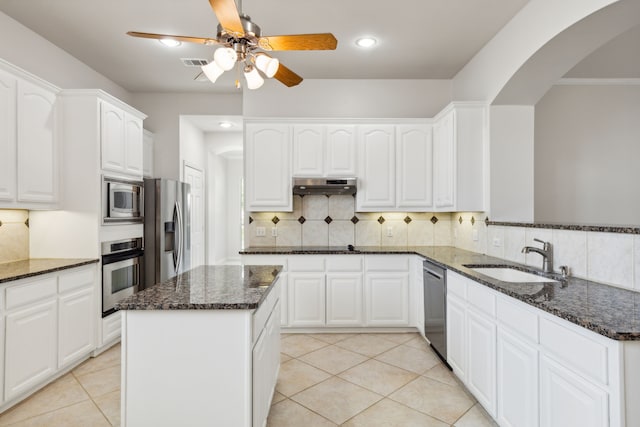 kitchen with ceiling fan, stainless steel appliances, white cabinets, tasteful backsplash, and sink