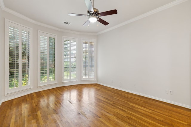 unfurnished room featuring crown molding, wood-type flooring, and a wealth of natural light