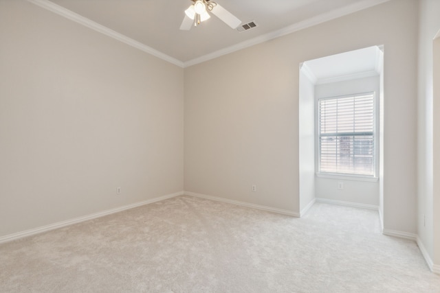 spare room with ceiling fan, ornamental molding, and light carpet