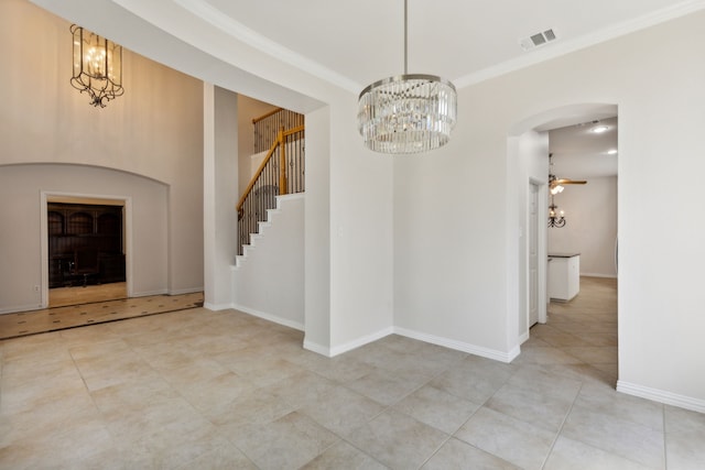 interior space featuring ceiling fan with notable chandelier and crown molding