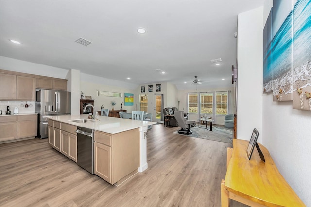 kitchen with visible vents, light wood-style flooring, appliances with stainless steel finishes, open floor plan, and a sink