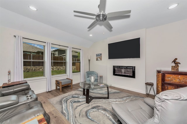 living room with ceiling fan, lofted ceiling, and light hardwood / wood-style floors