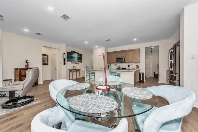 dining space featuring light wood-type flooring, visible vents, and recessed lighting