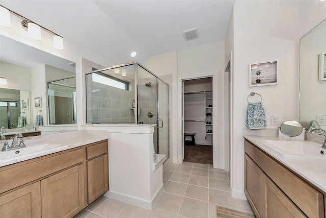 bathroom with a stall shower, a sink, and tile patterned floors