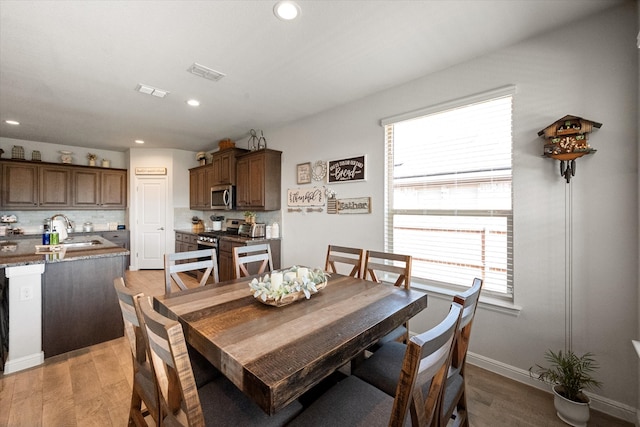 dining room featuring light wood-type flooring and sink