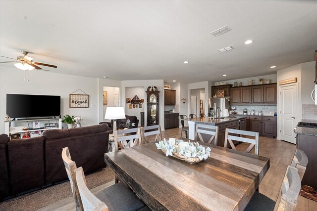 dining area with light hardwood / wood-style flooring and ceiling fan