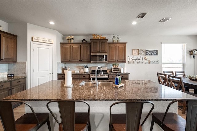 kitchen with tasteful backsplash, a breakfast bar area, stainless steel appliances, and a large island